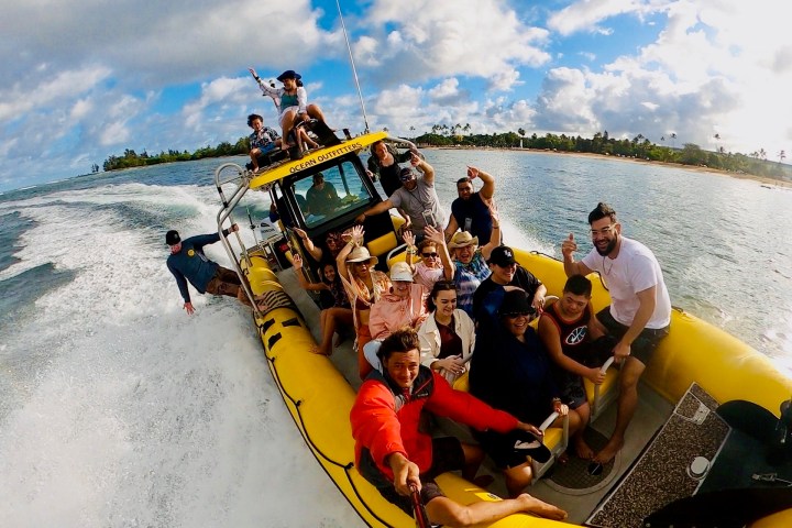 Group of people on a yellow speedboat, enjoying a sunny day on the water.