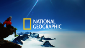 Person sitting on a mountain with National Geographic logo on a blue sky background.